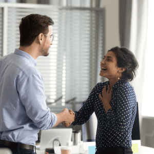 A woman happily meeting a coworker at the office