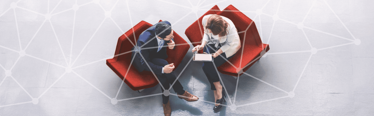 two people view from above sitting in red chairs having a meeting