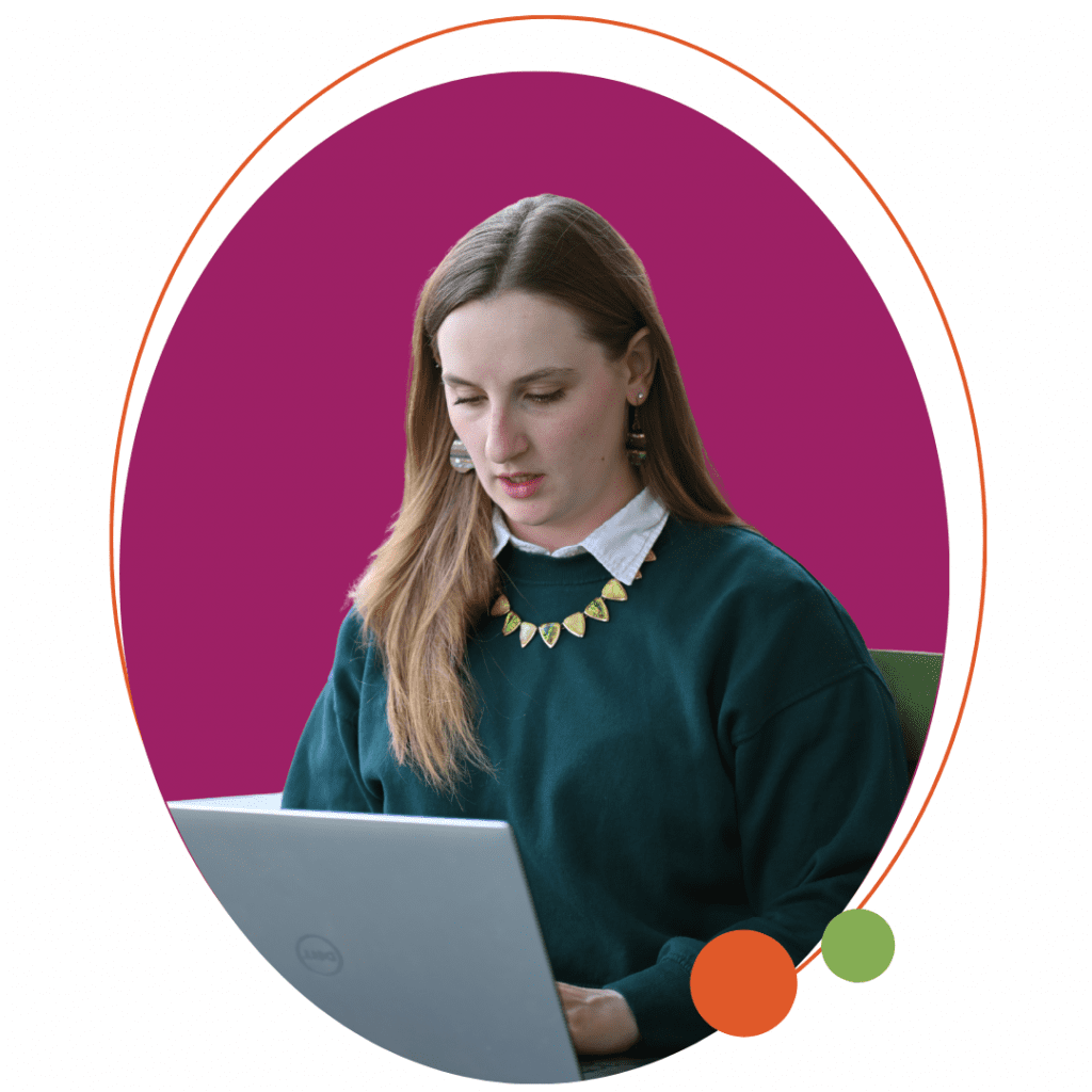 a woman sitting reading on a laptop