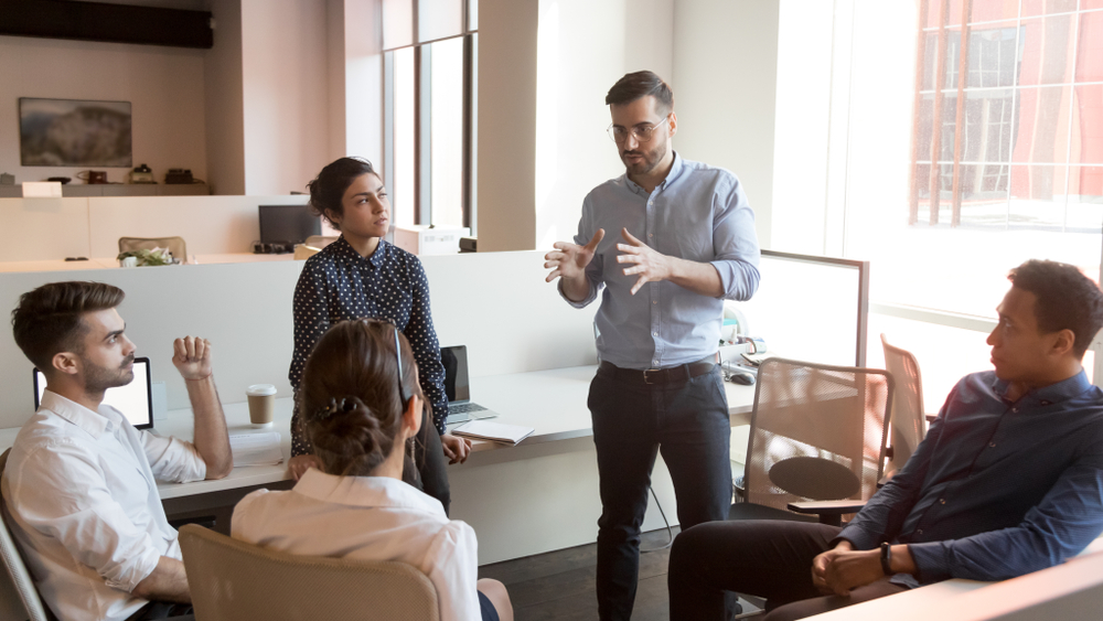 Senior professional applying mentor skills while guiding younger employees through a project