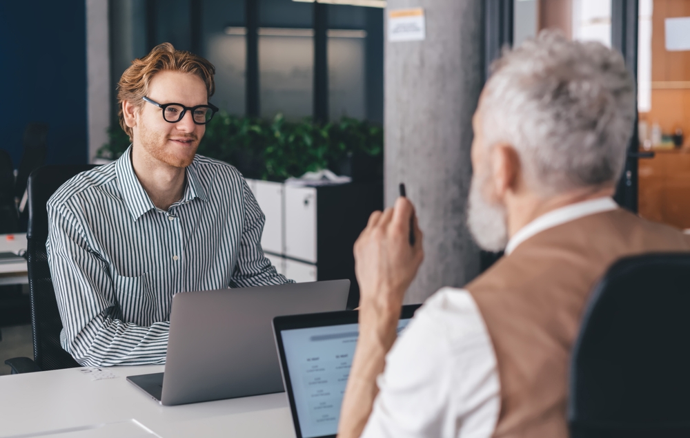 Senior employee mentoring a younger colleague as part of a workplace mentoring program