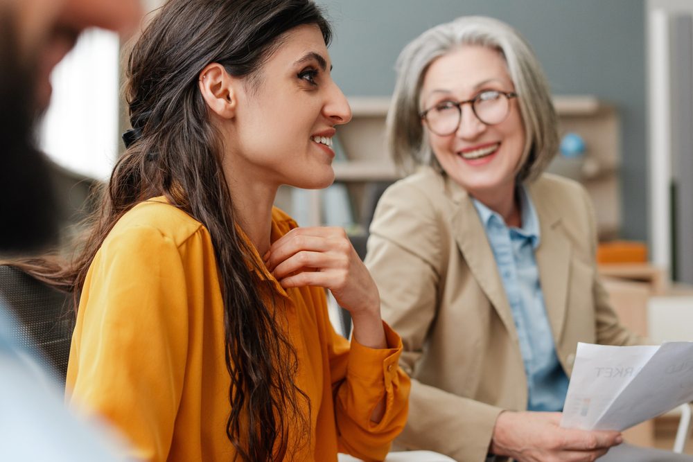 Two professionals in conversation as part of an association leadership mentoring program, reviewing notes together