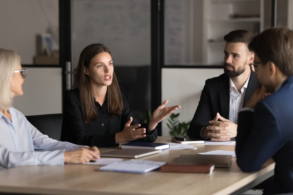 Experienced professionals sharing talent development strategies with younger colleagues in a workplace conversation
