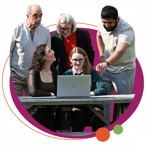a group of 5 people huddling around a computer at a table